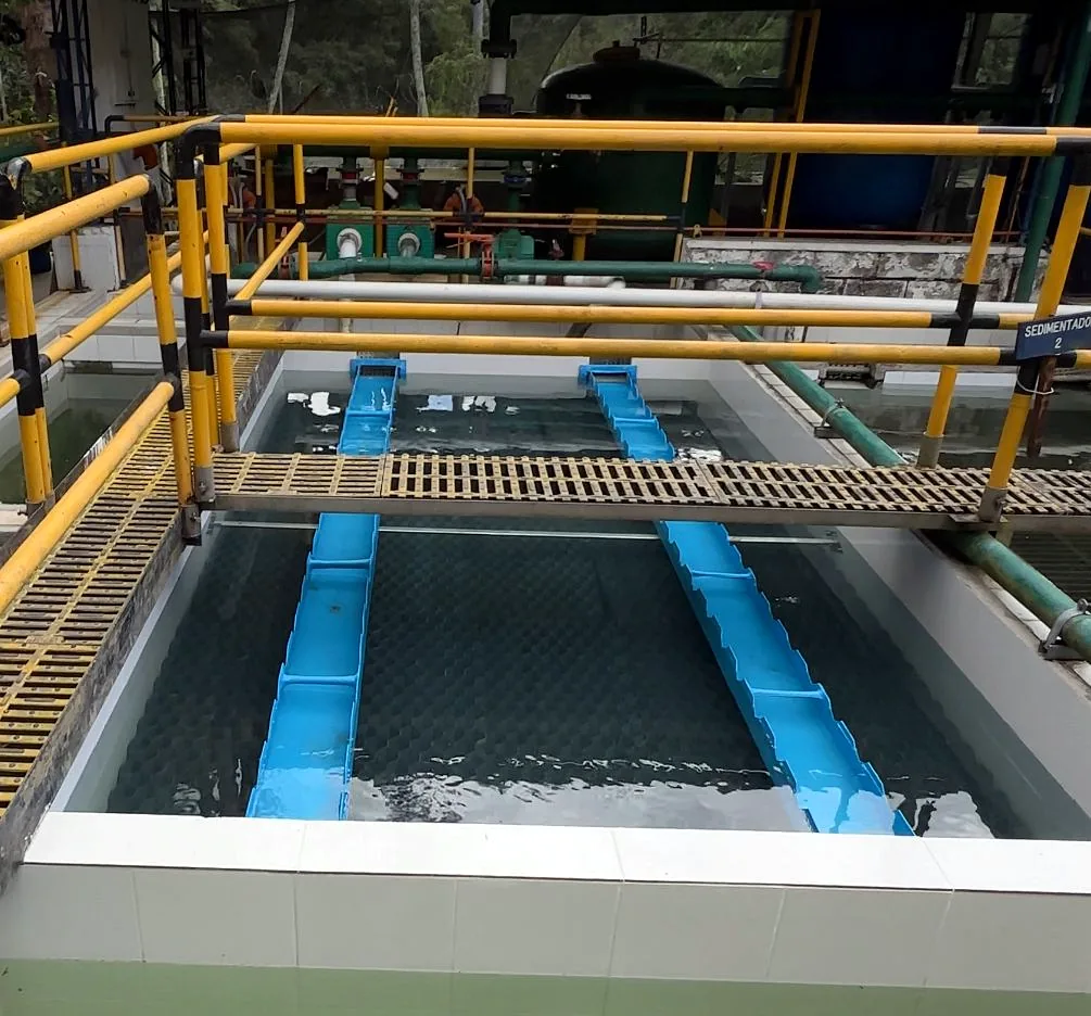 Sedimentador en operación con dos canaletas recolectoras en PRFV recogiendo el agua clarificada sobre la lámina de agua de una planta de tratamiento.