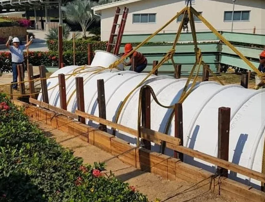 Sistema séptico modular en fibra de vidrio izado con aparejo en obra.
