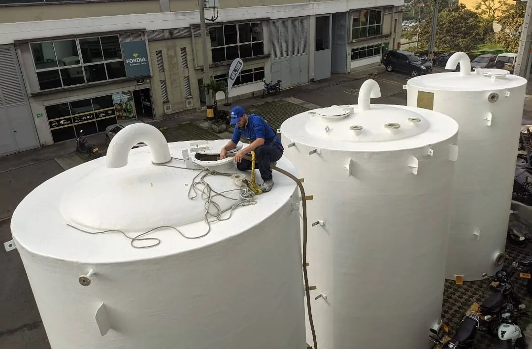 Tres tanques verticales en PRFV con sus manholes, bridas y anclajes ya montados.